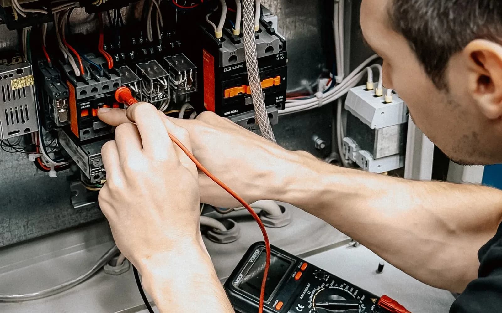 Électricien intervenant sur un tableau électrique lors d'un dépannage